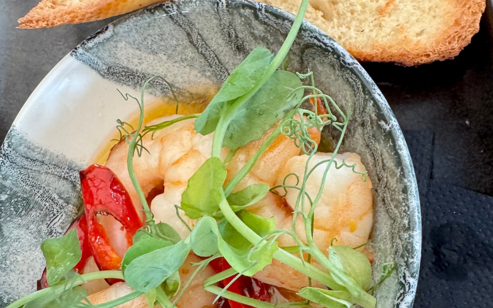 King prawns sizzling in chilli and garlic olive oil with red chilli and toasted bread at The Bank at Bude