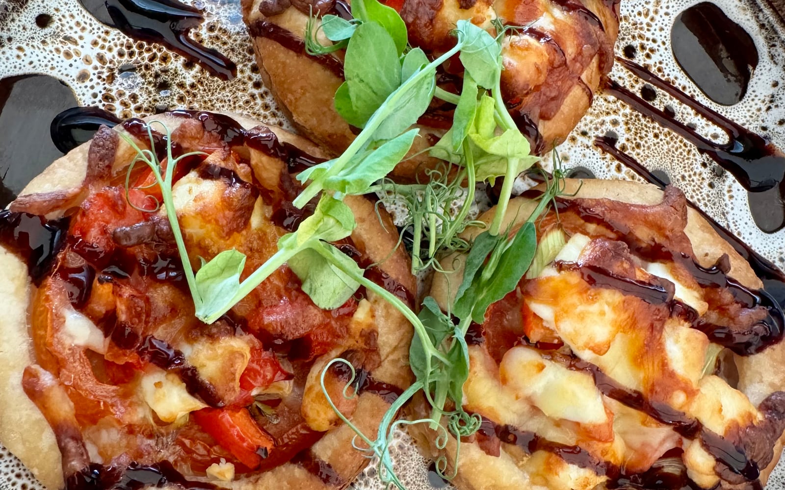 Open puff pastry pastel de mano parcels with tomato, pepper and melted cheese, balsamic drizzle, at The Bank at Bude